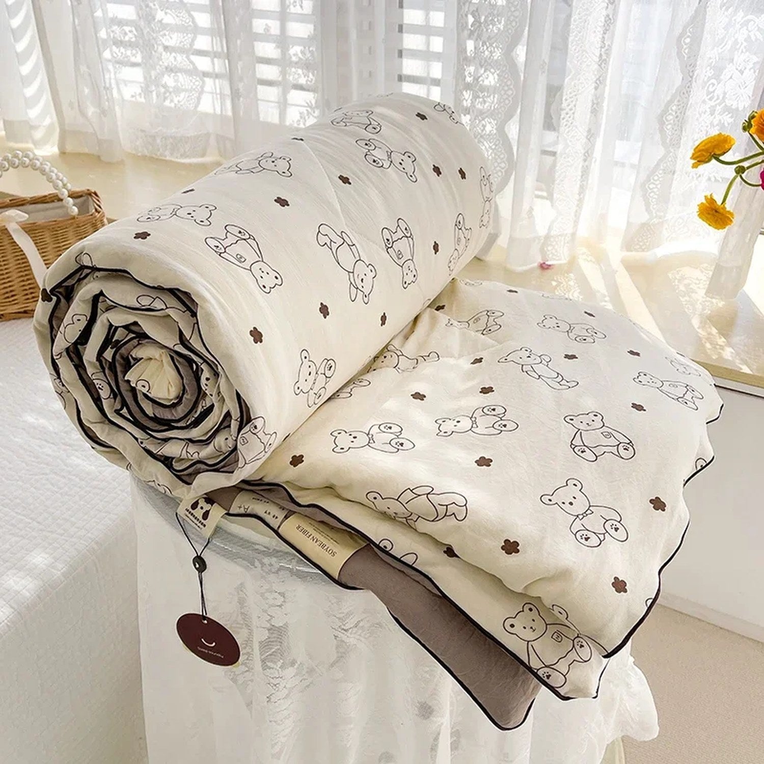 Couette légère à motif petits ours posée sur un lit, vue d'ensemble avec oreillers