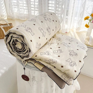 Couette légère à motif petits ours posée sur un lit, vue d'ensemble avec oreillers