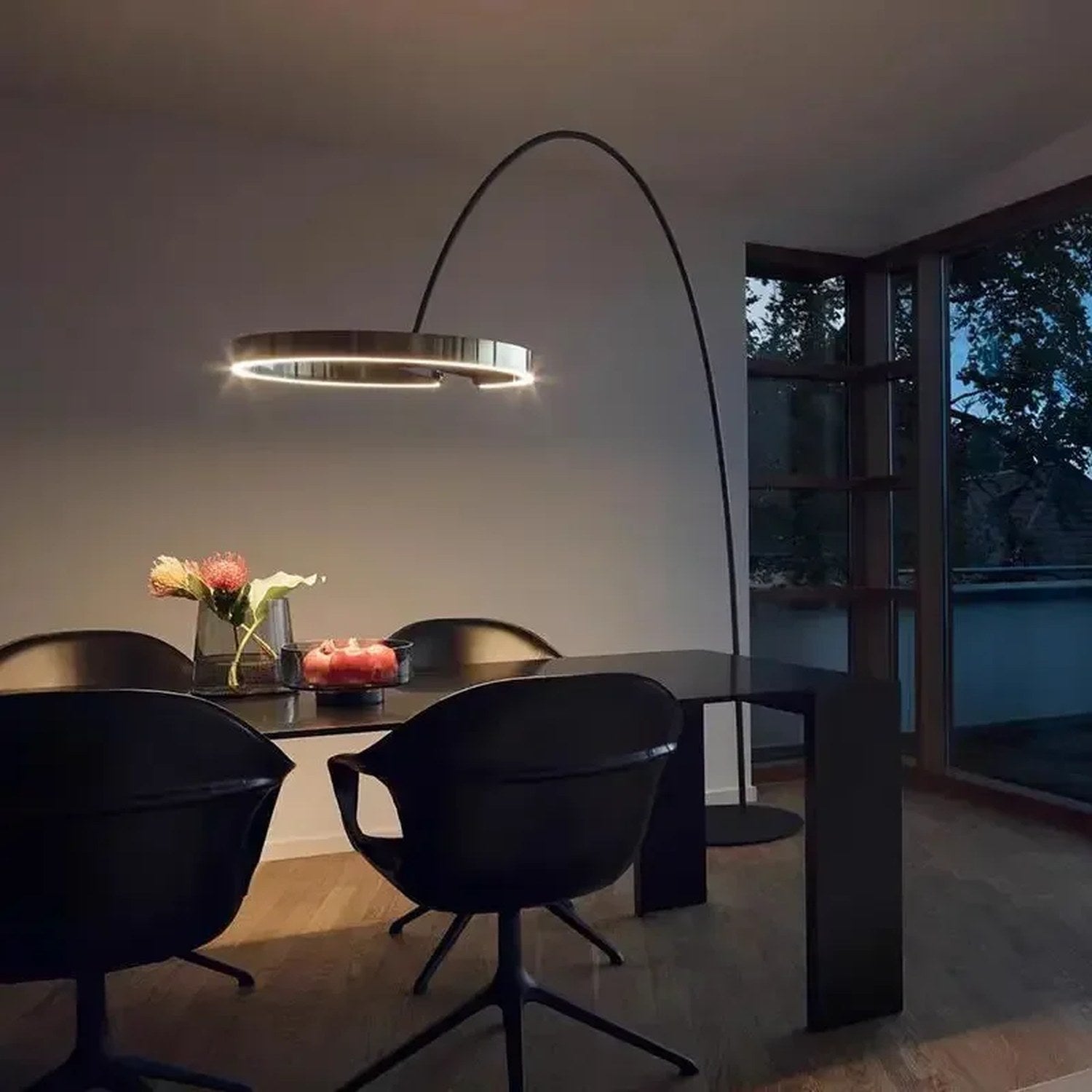 Lampadaire arc doré au-dessus d'une table à manger noire, vue d'ensemble