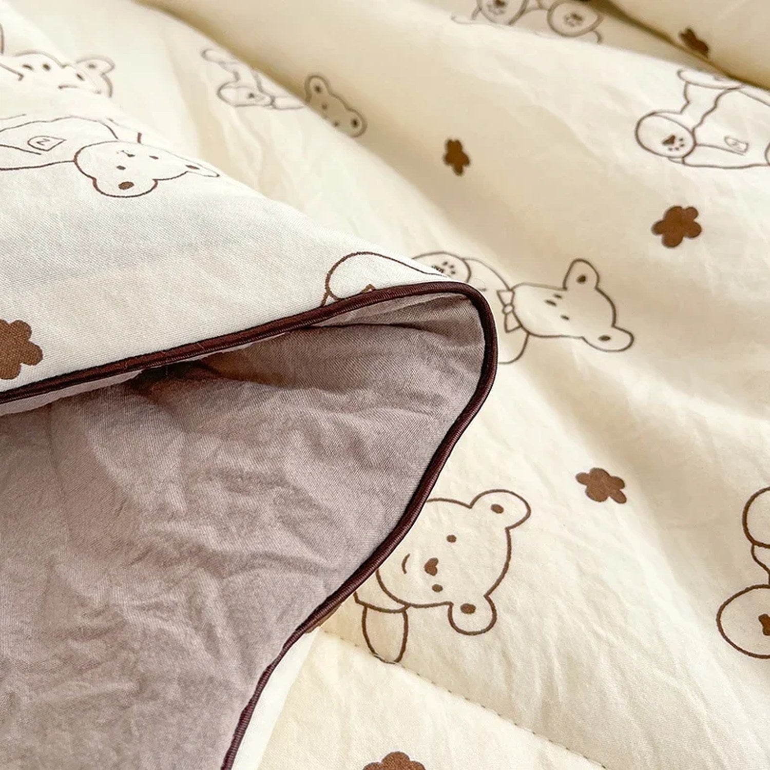Gros plan sur le tissu et la bordure de la couette légère à motif petits ours