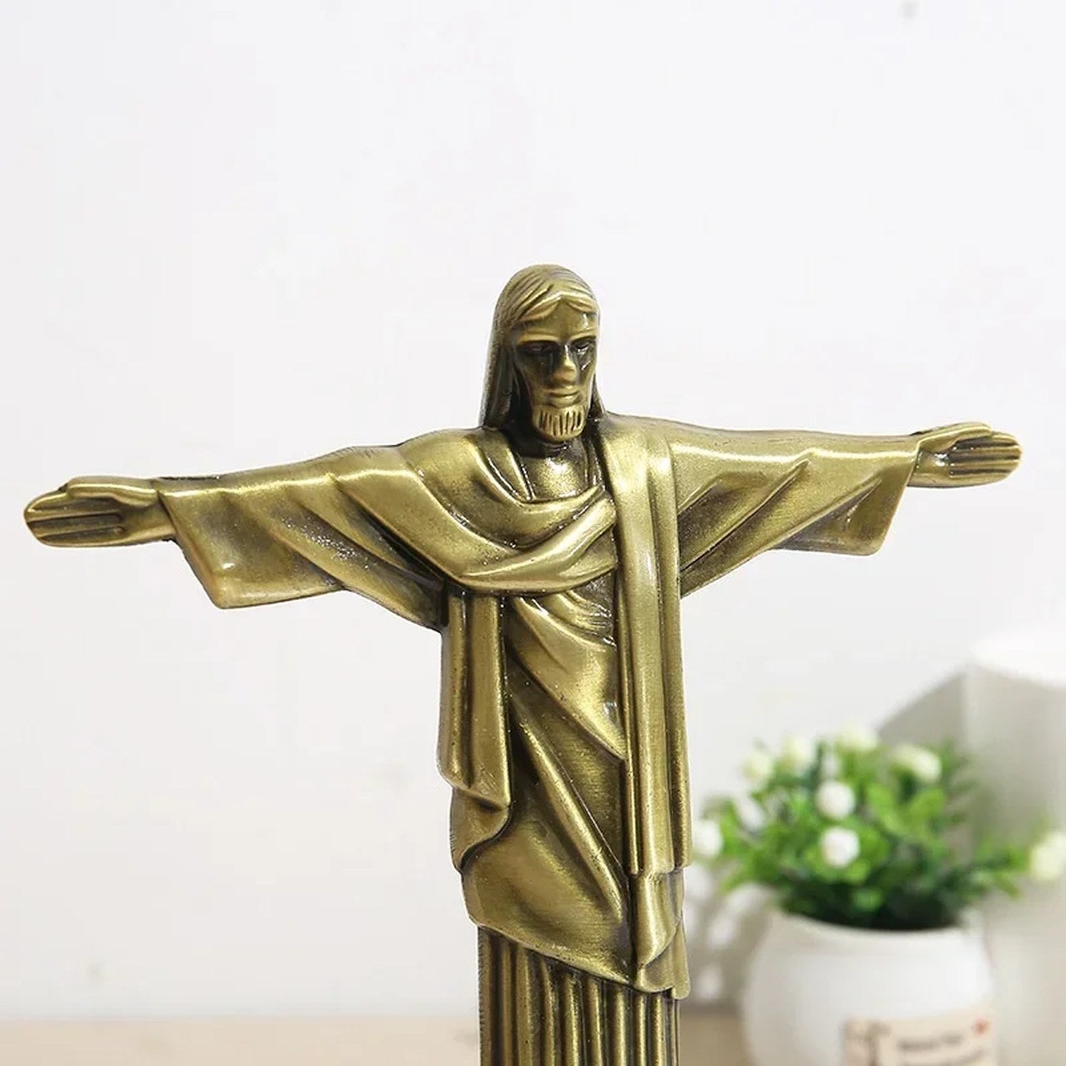 Gros plan sur les bras et le visage de la statuette Christ Rédempteur finition bronze
