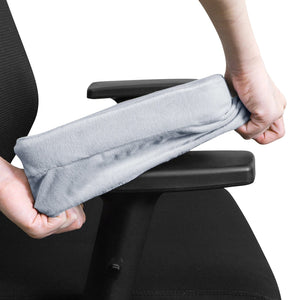 Mains installant une housse d'accoudoir en velours gris sur une chaise de bureau