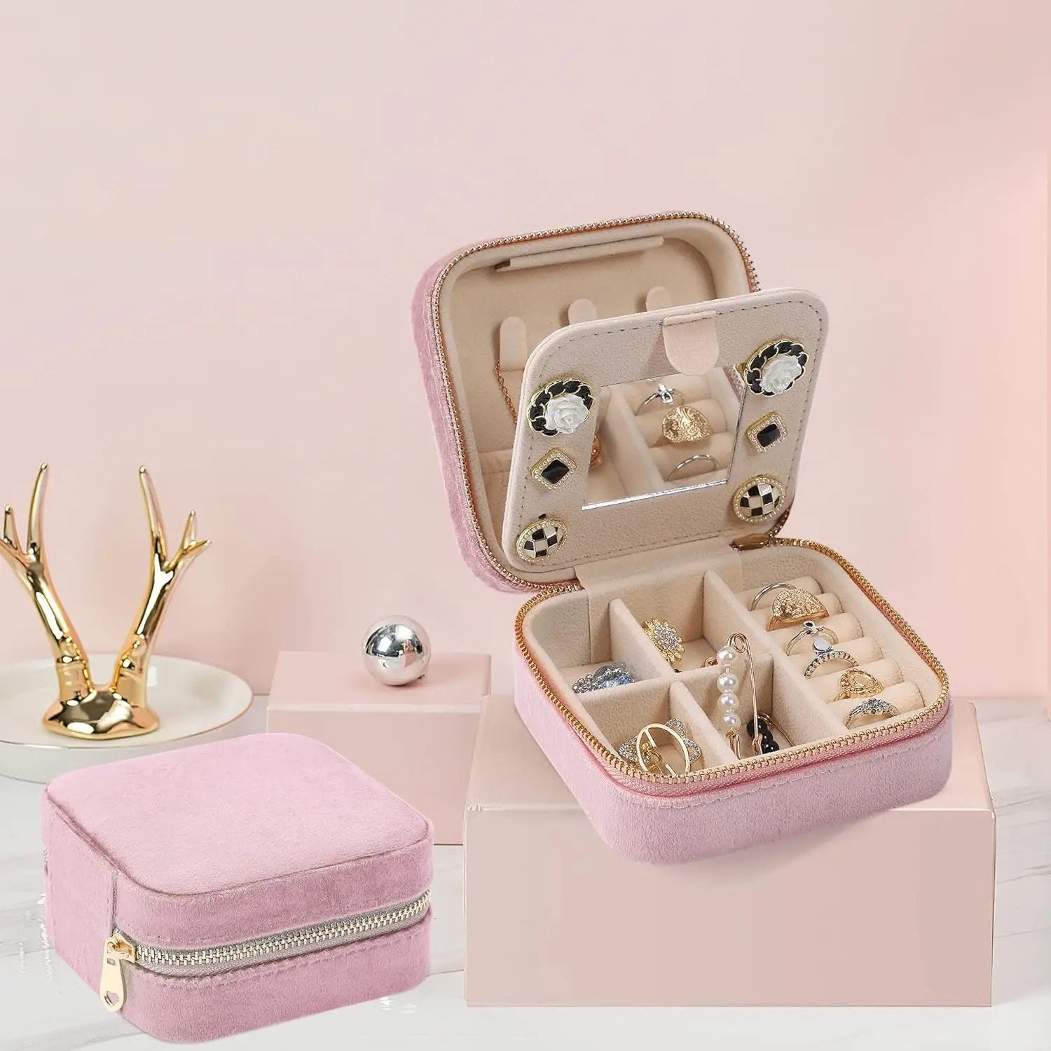 Boîte à bijoux en velours rose ouverte et fermée présentée sur un décor rose