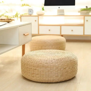 Pouf rond en paille tressée dans un salon avec meuble en bois clair