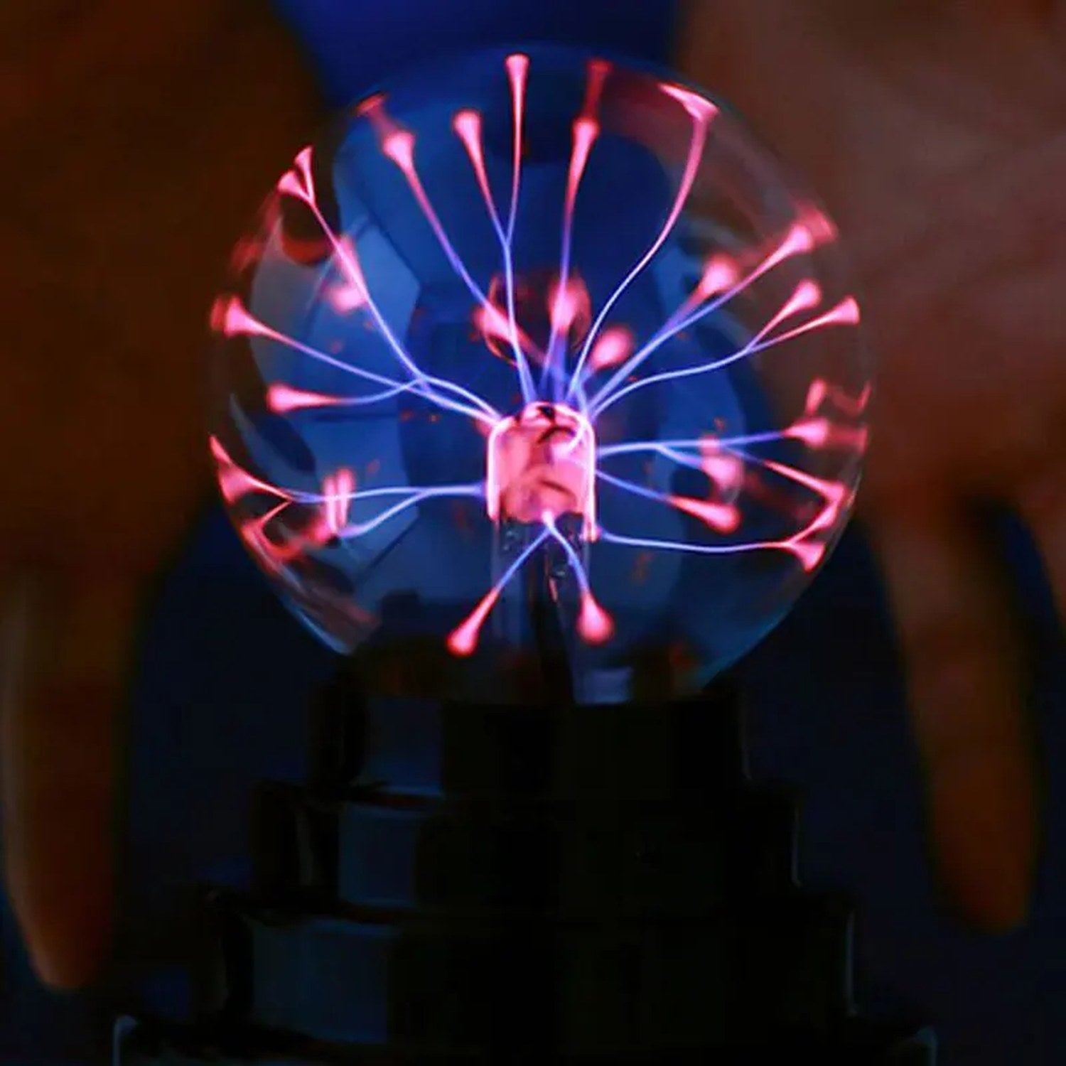 Lampe boule de plasma allumée aux filaments violets dans une ambiance sombre