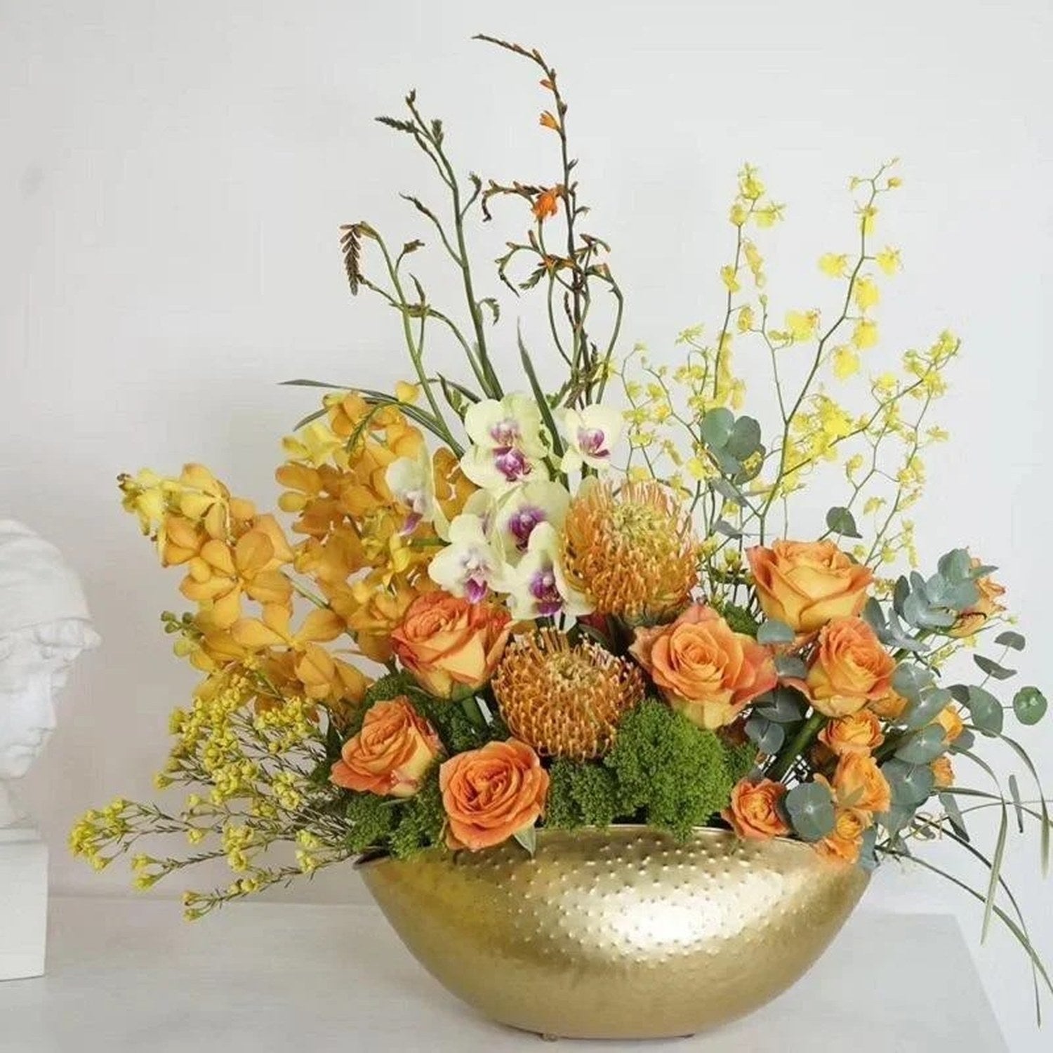 Coupe dorée garnie d un bouquet de roses orangées