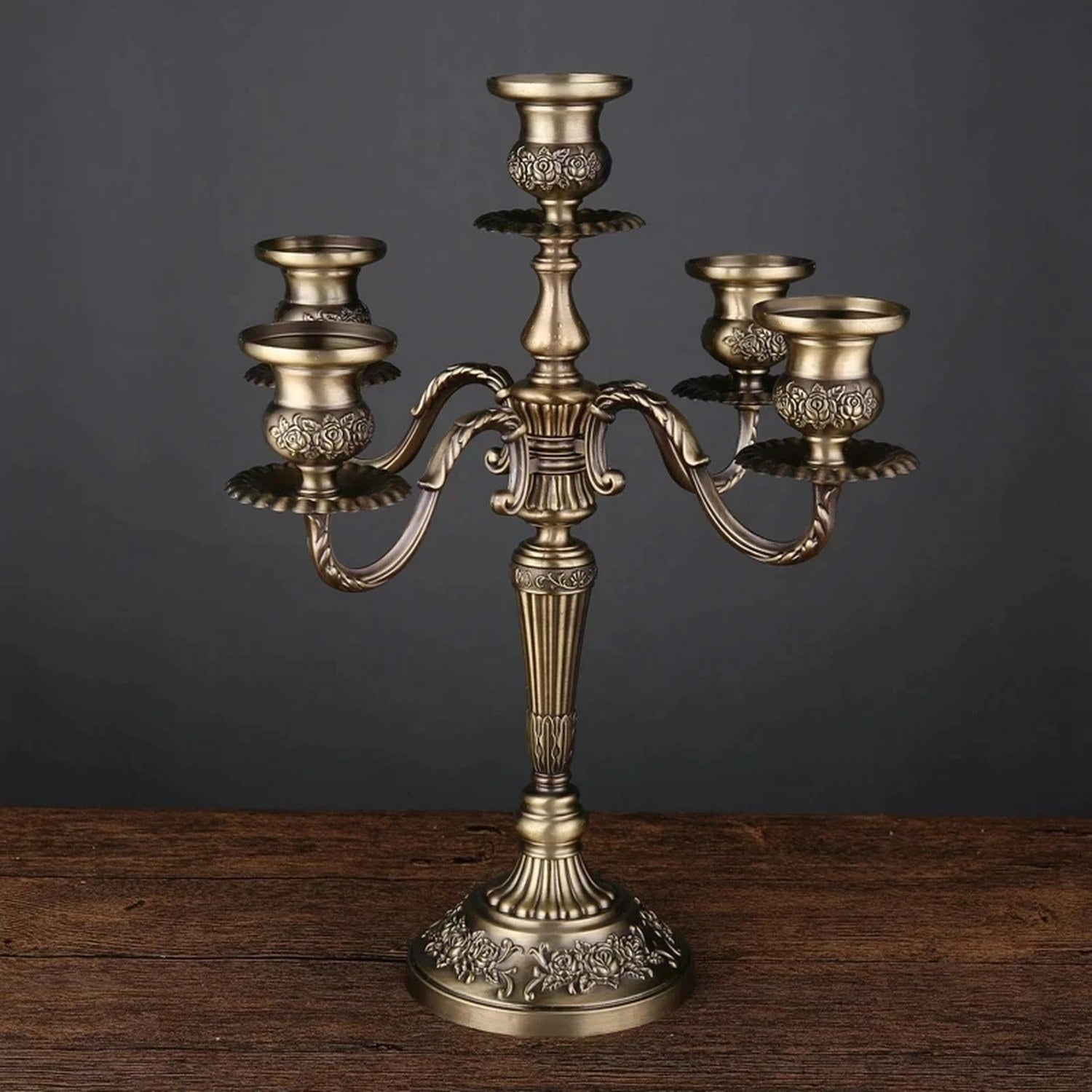 Chandelier sculpté en métal bronze à cinq branches sur fond sombre élégant