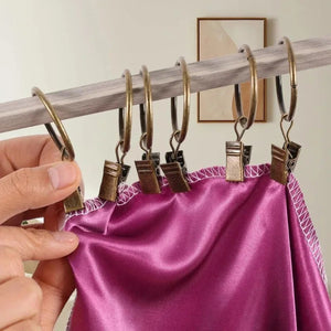 Anneaux à rideau à clips bronze ancien tenant un rideau satiné violet
