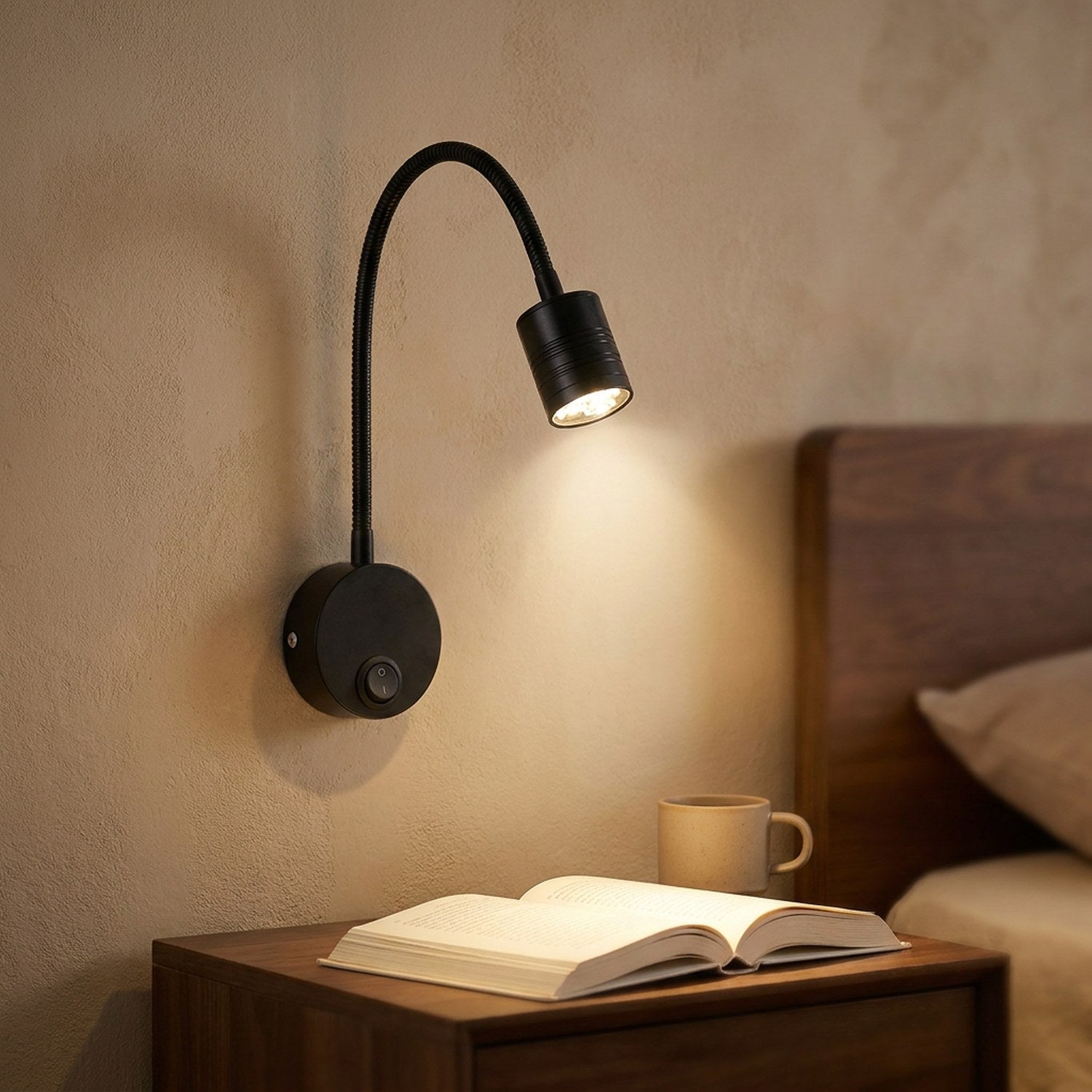 Applique murale noire au bras flexible avec spot LED allumé au dessus d'une table de chevet