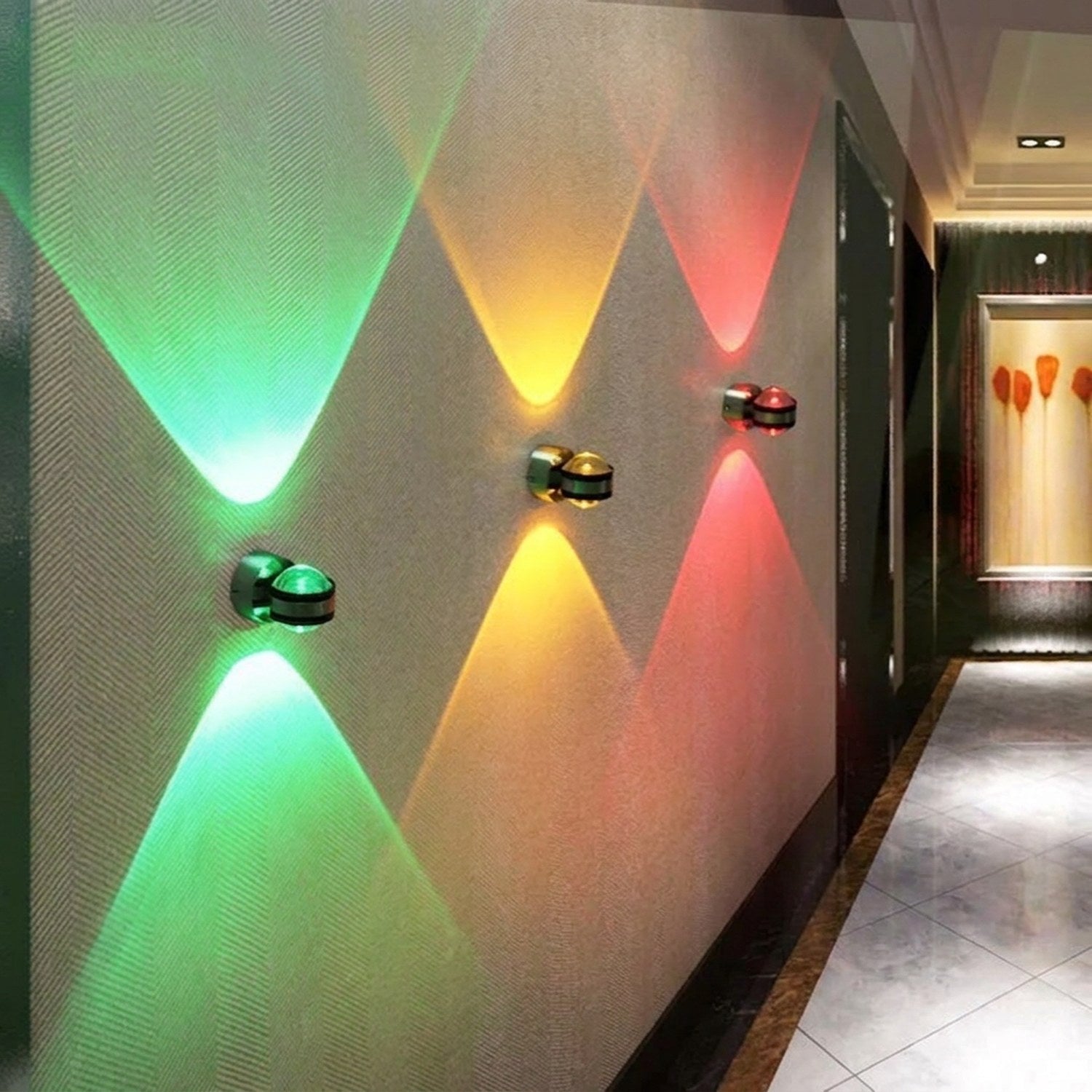 Trois appliques murales LED rondes vert jaune et rouge dans un couloir