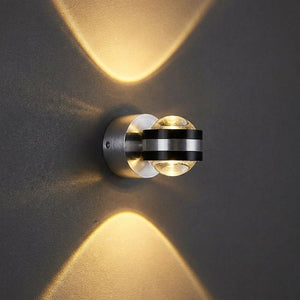 Applique murale LED ronde en lumière blanc chaud allumée sur un mur sombre