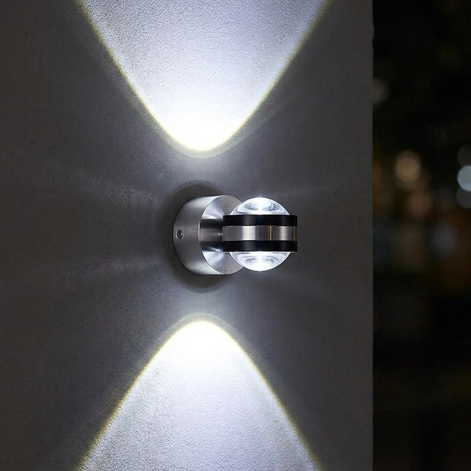 Applique murale LED ronde en lumière blanche froide allumée sur un mur sombre