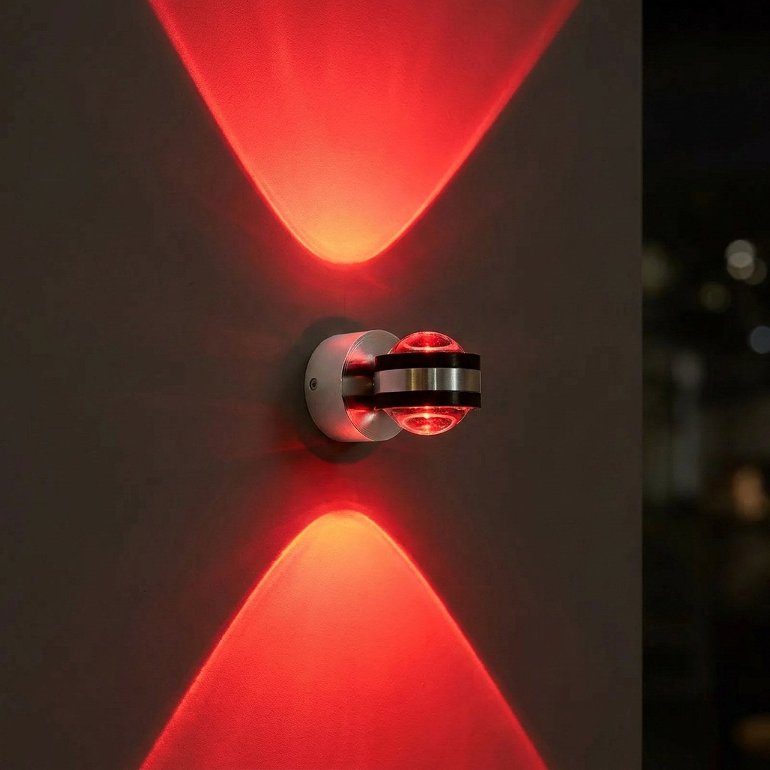 Applique murale LED ronde en lumière rouge allumée sur un mur sombre