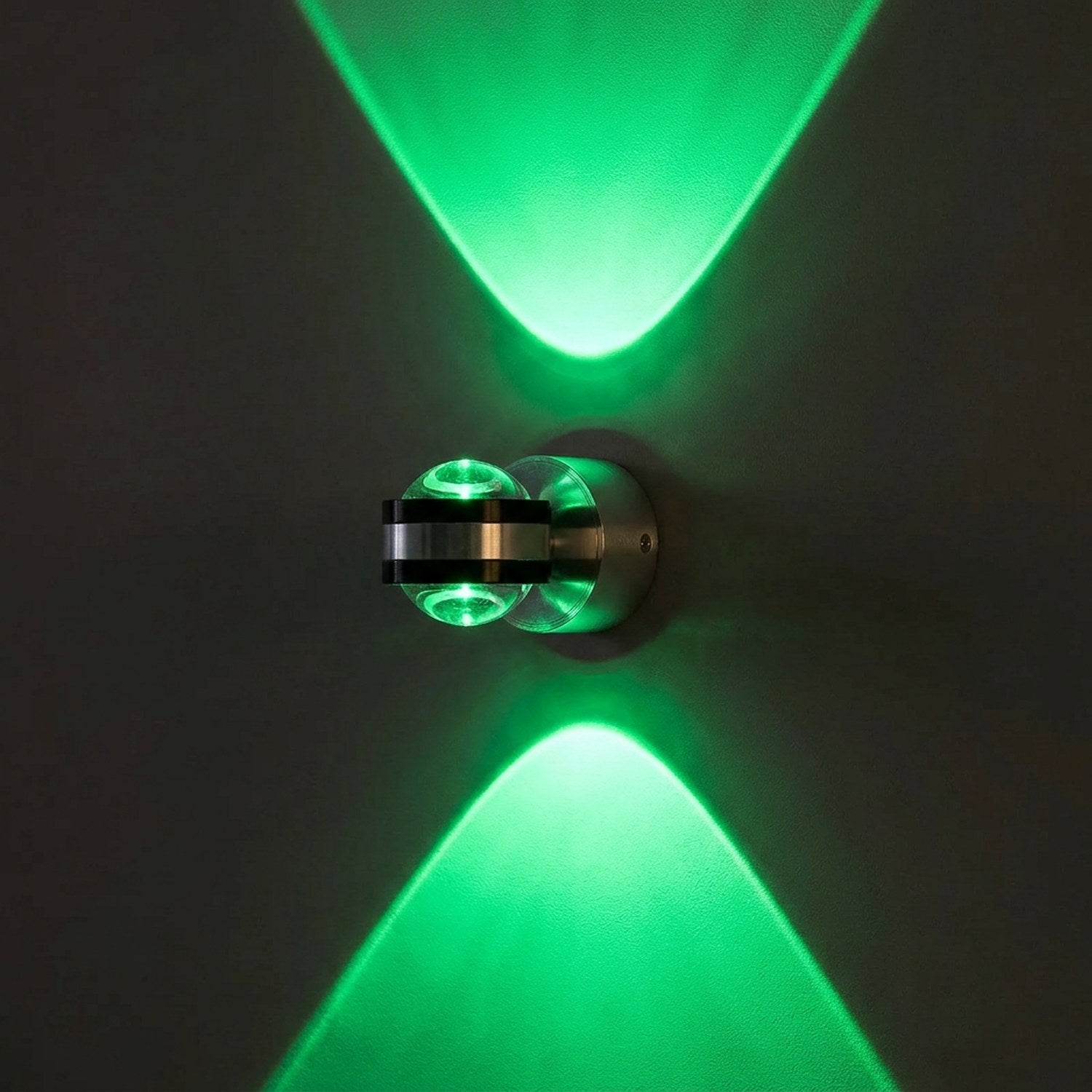 Applique murale LED ronde en lumière verte allumée sur un mur sombre