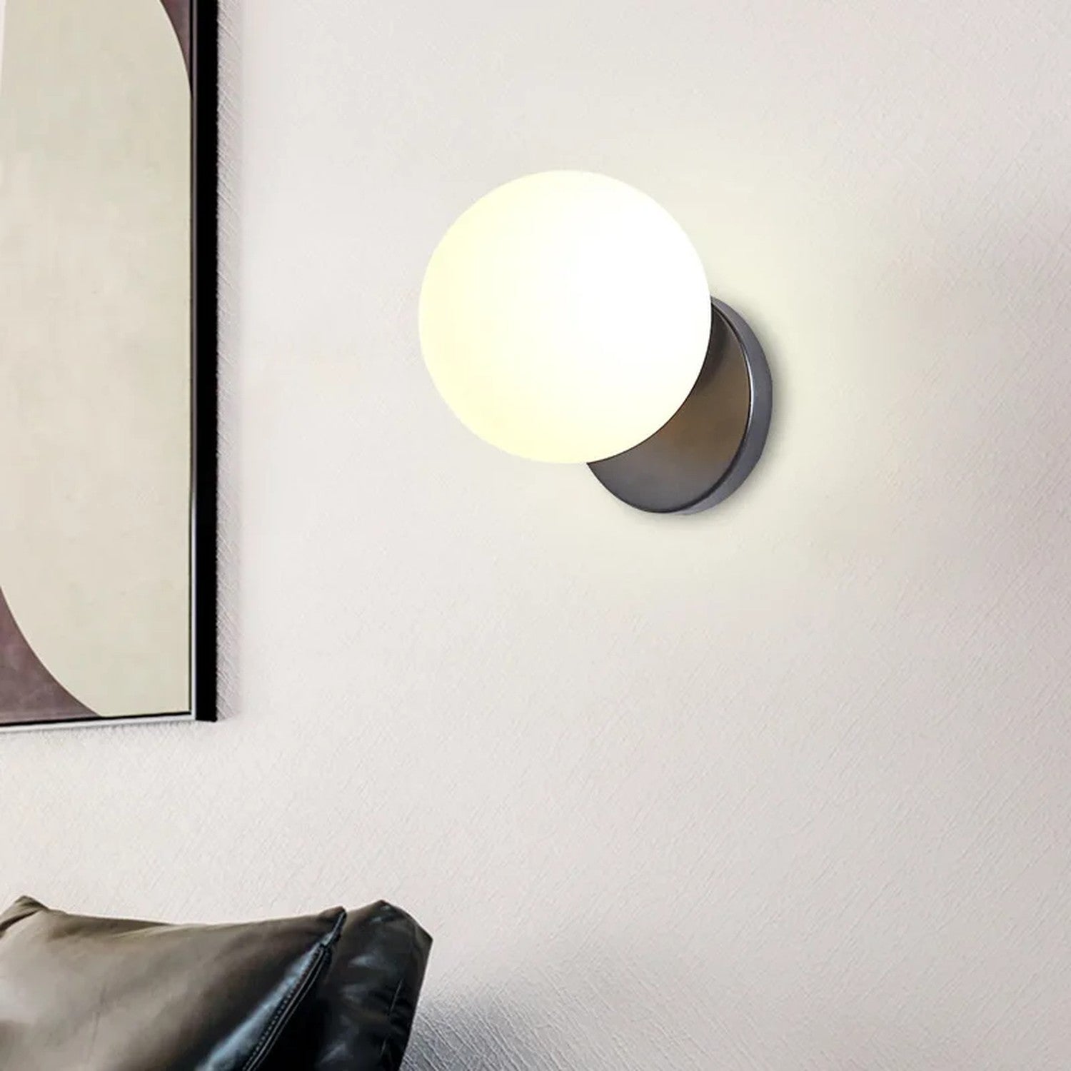 Applique murale boule de verre blanc opale allumée dans un salon moderne