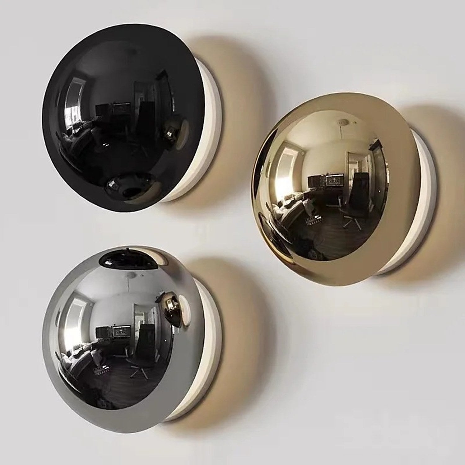 Applique murale ronde disponible en finitions noir argenté et doré avec halo lumineux chaud