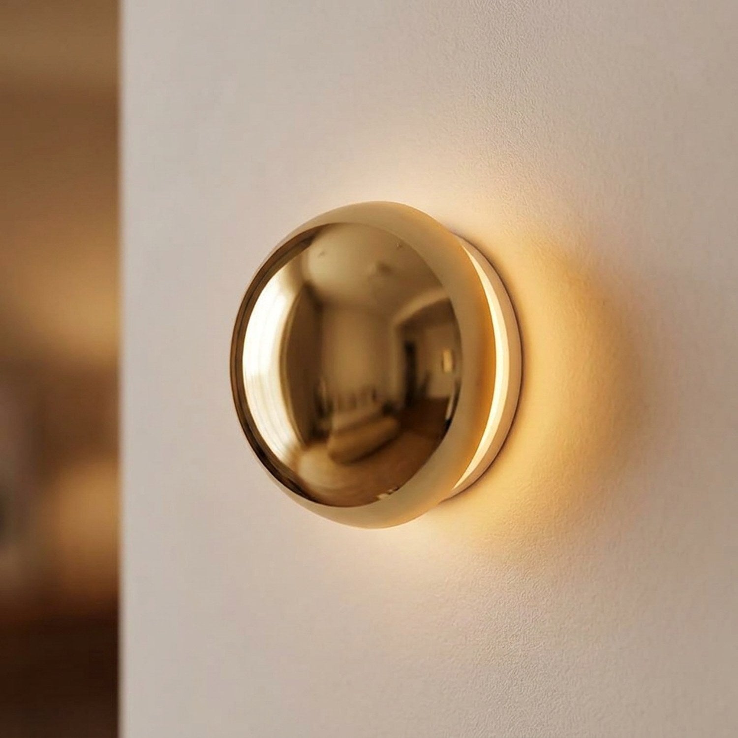Applique murale ronde en finition dorée brillante avec halo lumineux chaud