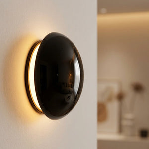 Applique murale ronde en finition noire brillante avec halo lumineux chaud