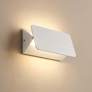 Applique murale LED blanche en aluminium diffusant une lumière chaude sur un mur clair