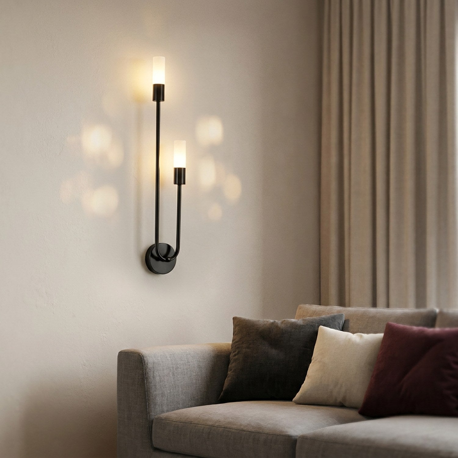 Applique murale noire allumée au-dessus d'une table de chevet dans une chambre cosy