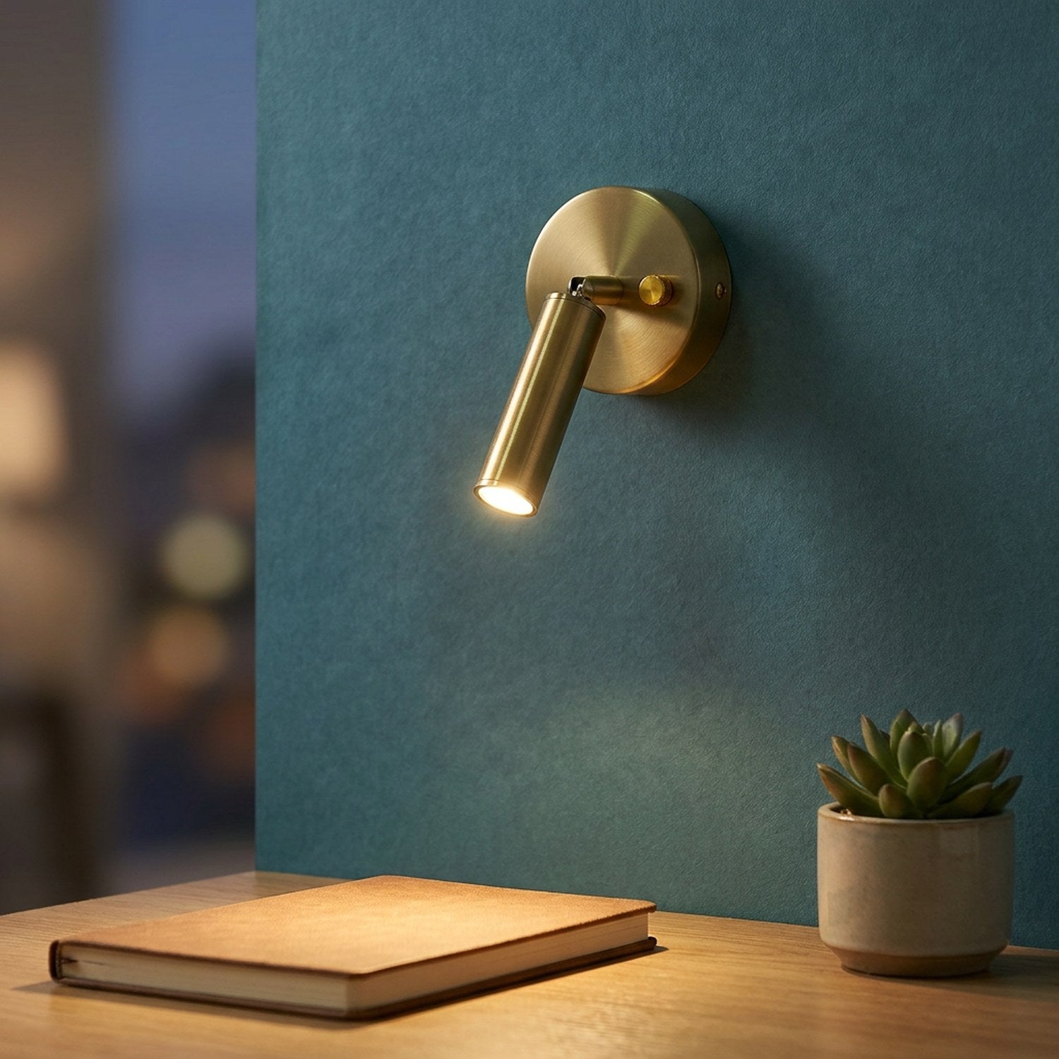 Applique murale dorée éclairant un bureau avec plante et carnet
