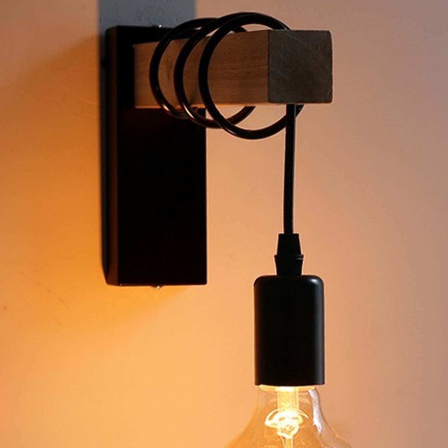 Applique murale noire allumée la nuit diffusant une lumière chaleureuse