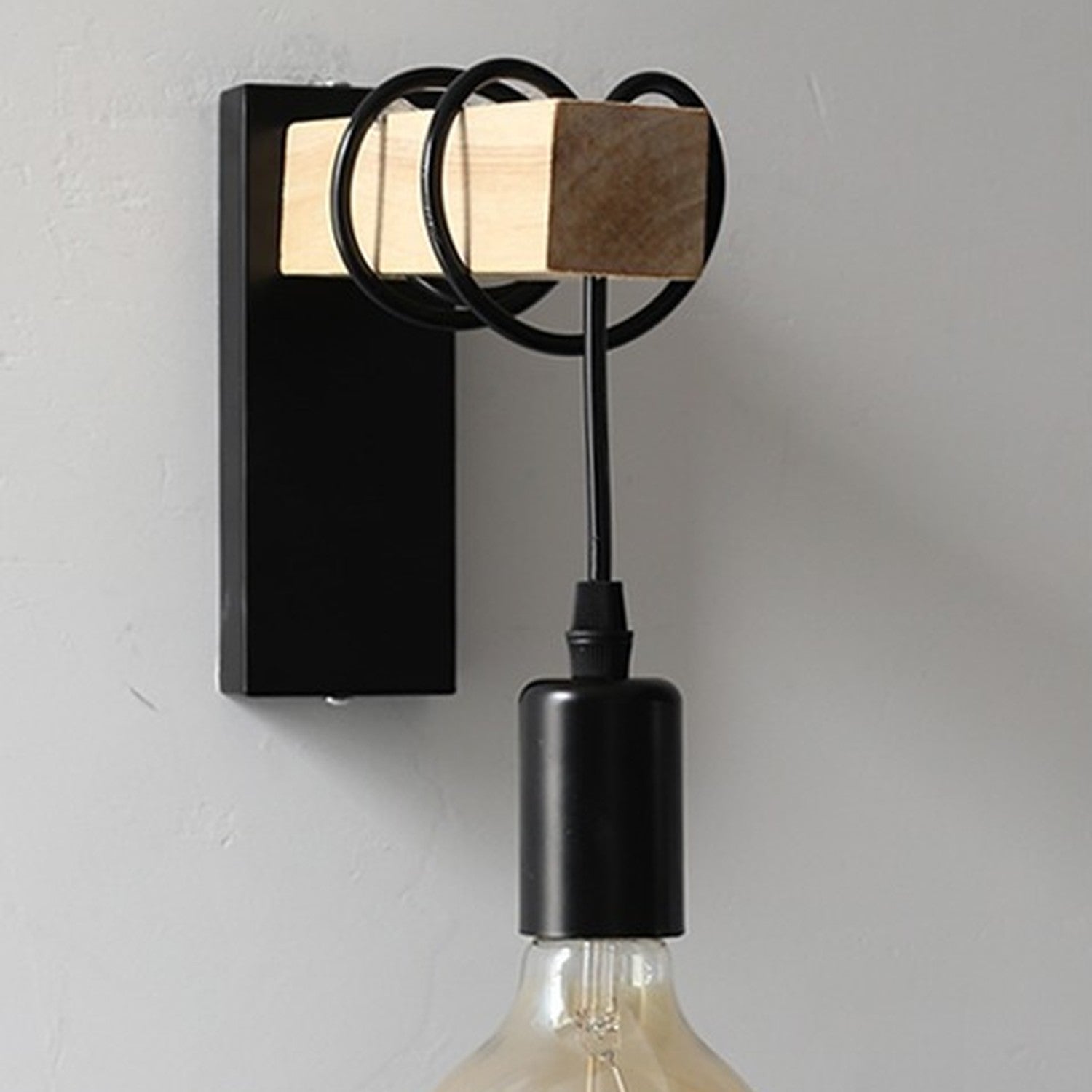 Applique murale noire vue de face avec douille suspendue et ampoule vintage