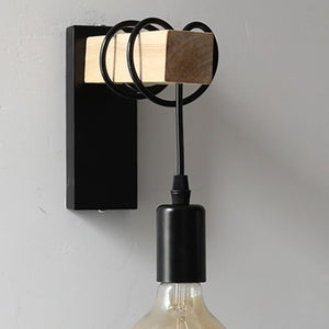Applique murale noire vue de face avec douille suspendue et ampoule vintage