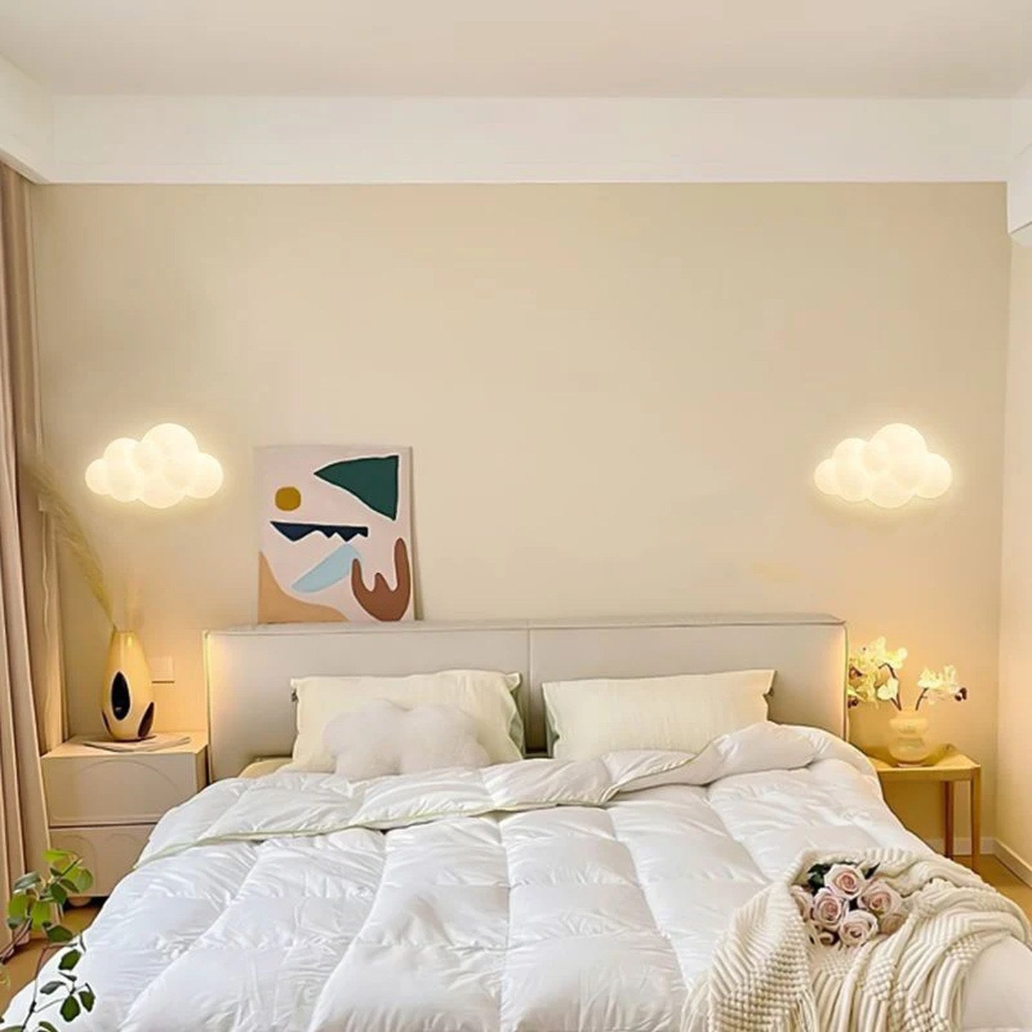 Deux appliques murales nuage allumées de part et d'autre d'un lit dans une chambre cocooning