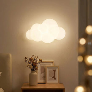 Applique murale nuage au-dessus d'une table de chevet avec fleurs séchées