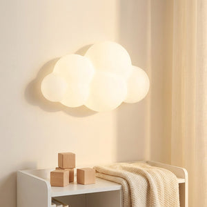Applique murale nuage allumée au dessus d'une étagère basse avec cubes en bois