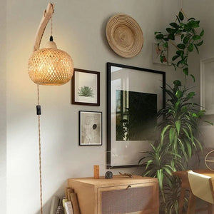 Applique murale en rotin dans un salon bohème avec cadres et plantes