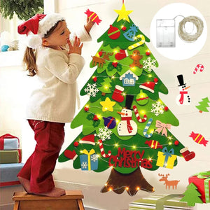 Enfant décorant l'arbre de Noël en feutre avec ornements colorés et guirlande lumineuse