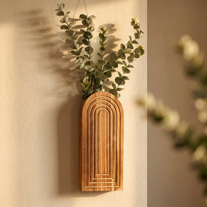 Vase mural en bois arqué bohème avec des tiges d eucalyptus sur un mur clair
