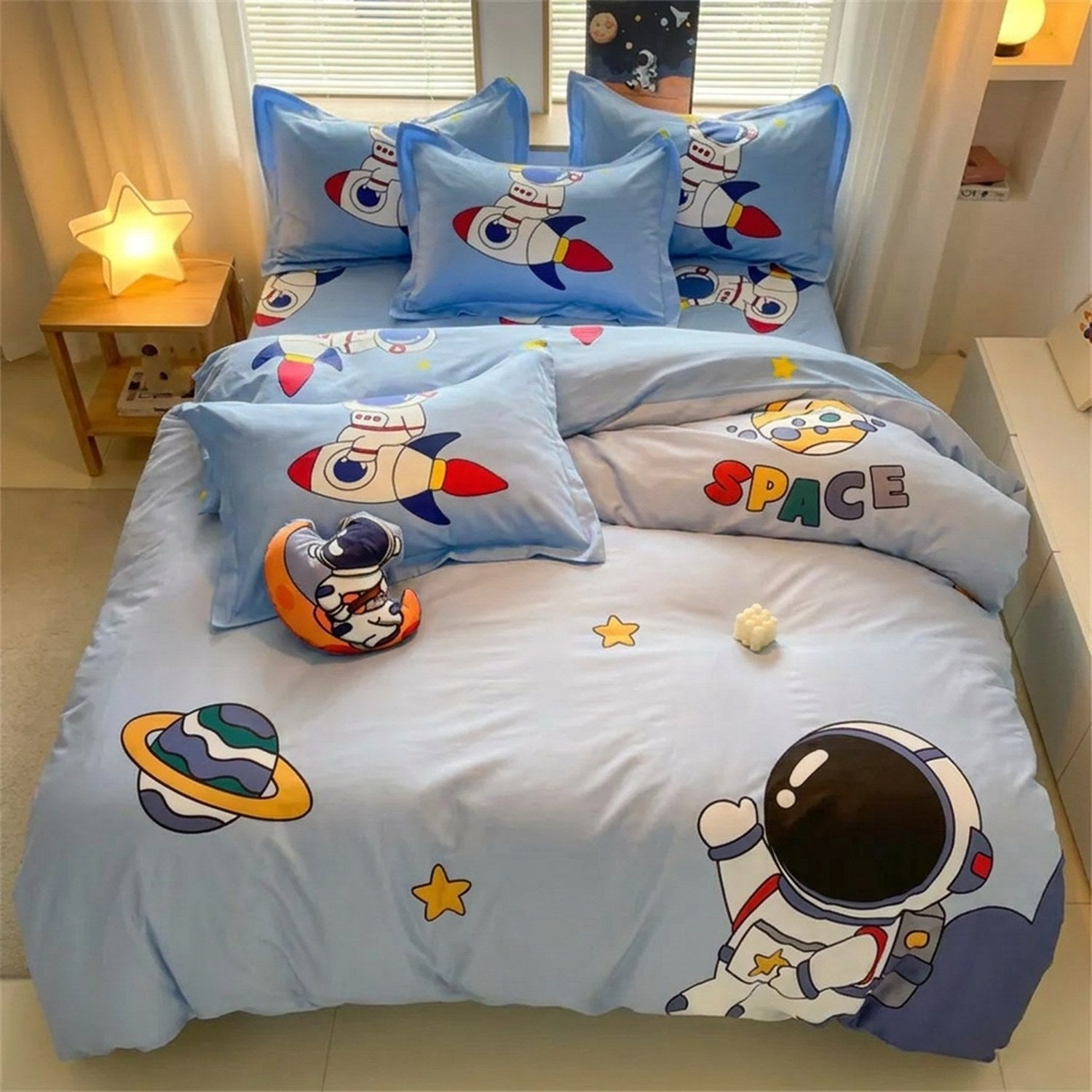 Parure de lit enfant astronaute dans une chambre avec veilleuse étoile allumée