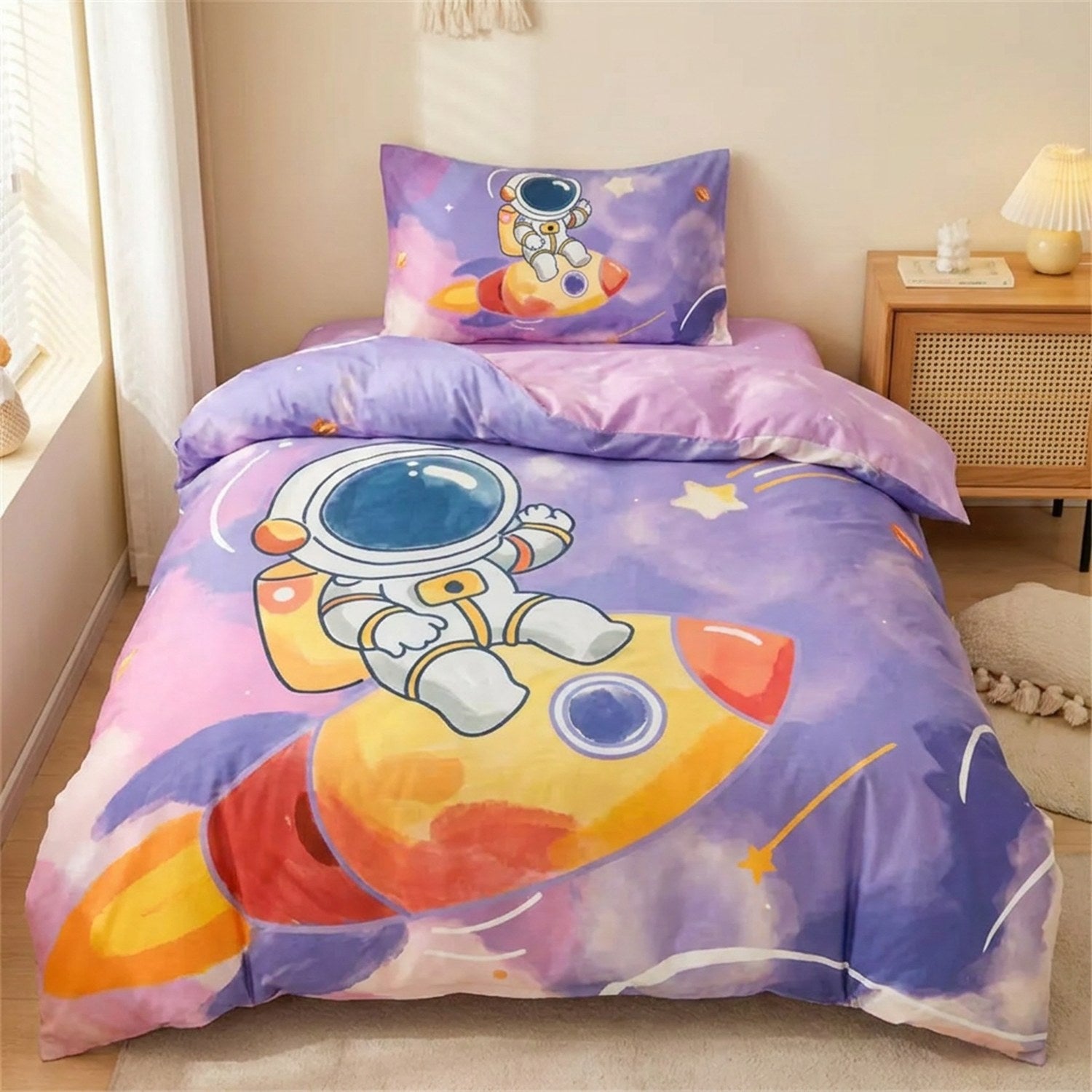 Parure de lit enfant motif astronaute violet et rose sur un lit fait