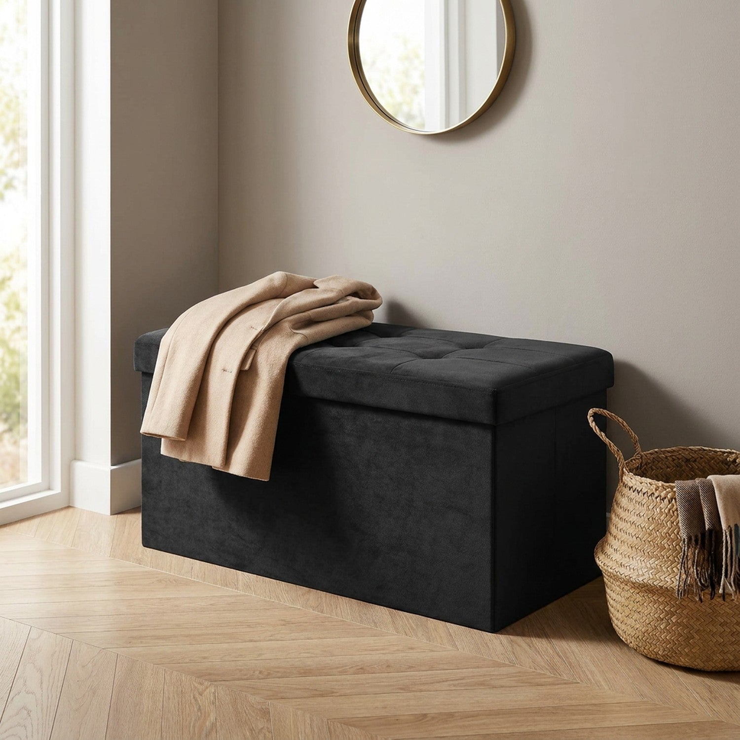 Plaid beige posé sur un banc coffre en velours noir dans une entrée avec miroir