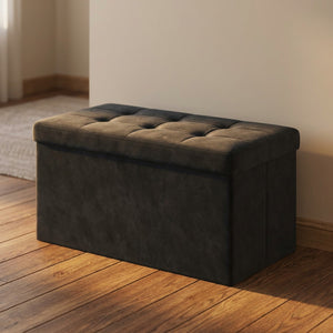 Banc coffre de rangement en velours noir capitonné dans une entrée chaleureuse