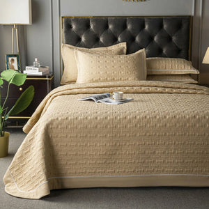Couvre-lit matelassé beige avec deux taies assorties sur un lit