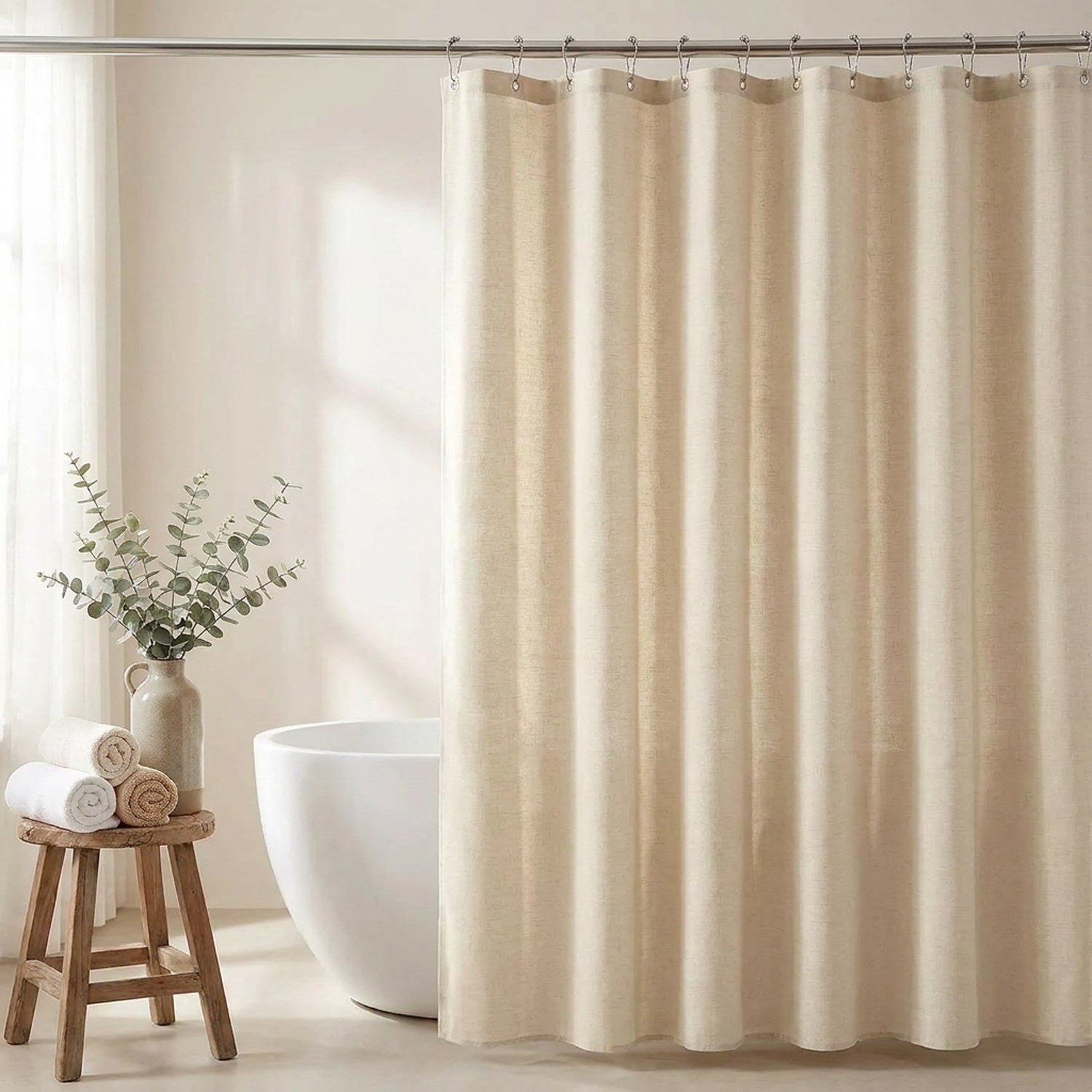 Rideau de douche aspect lin beige suspendu à une tringle dans une salle de bain lumineuse et épurée