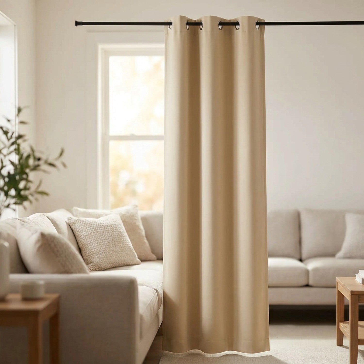 Rideau occultant beige à œillets suspendu à une tringle devant une fenêtre dans un salon lumineux