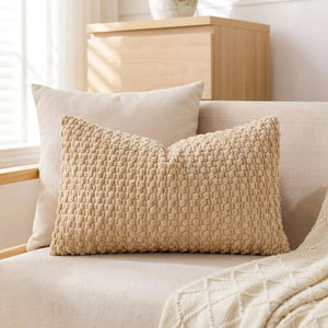 housse de coussin rectangulaire en maille texturée beige sur un canapé en lin