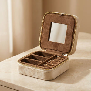 Boîte à bijoux de voyage en velours beige ouverte avec miroir intérieur