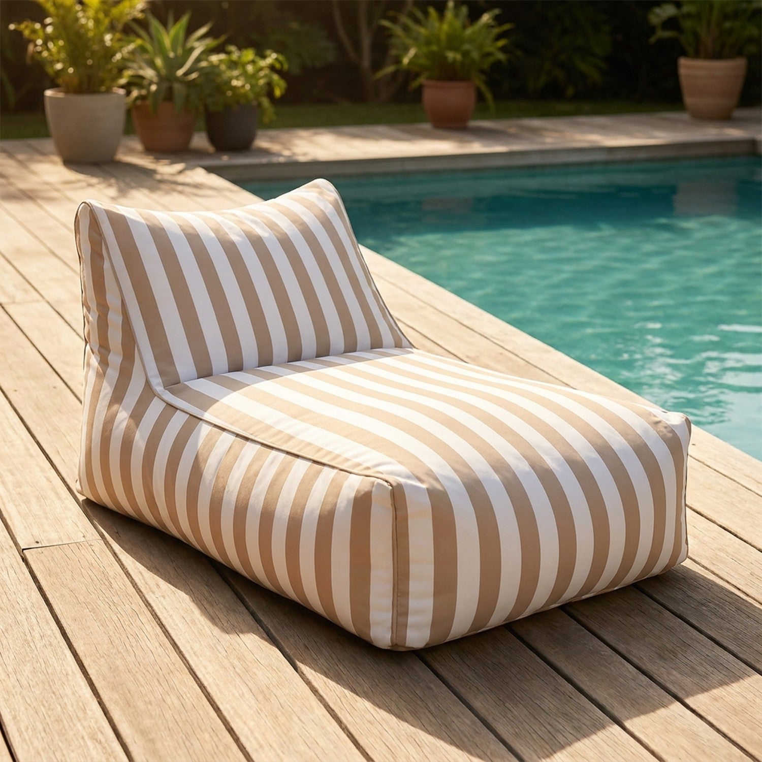 Pouf géant flottant à rayures beige posé au bord d'une piscine