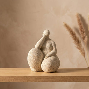 Statue de femme ronde blanc sablé assise pensive sur une étagère