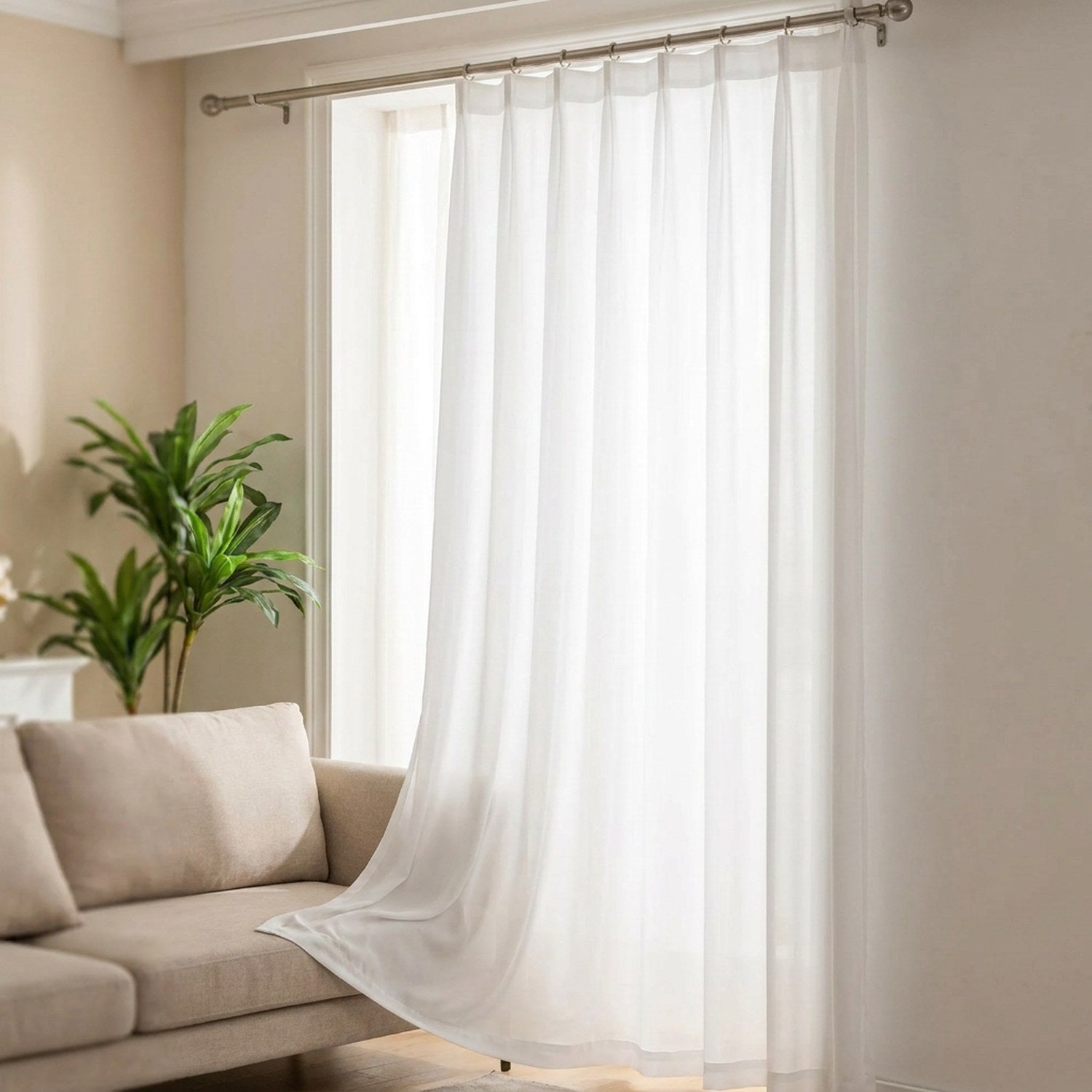 Voilage uni blanc suspendu à une fenêtre de salon lumineux filtrant la lumière du jour