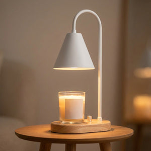 Lampe chauffe-bougie blanche avec socle en bois allumée sur une petite table