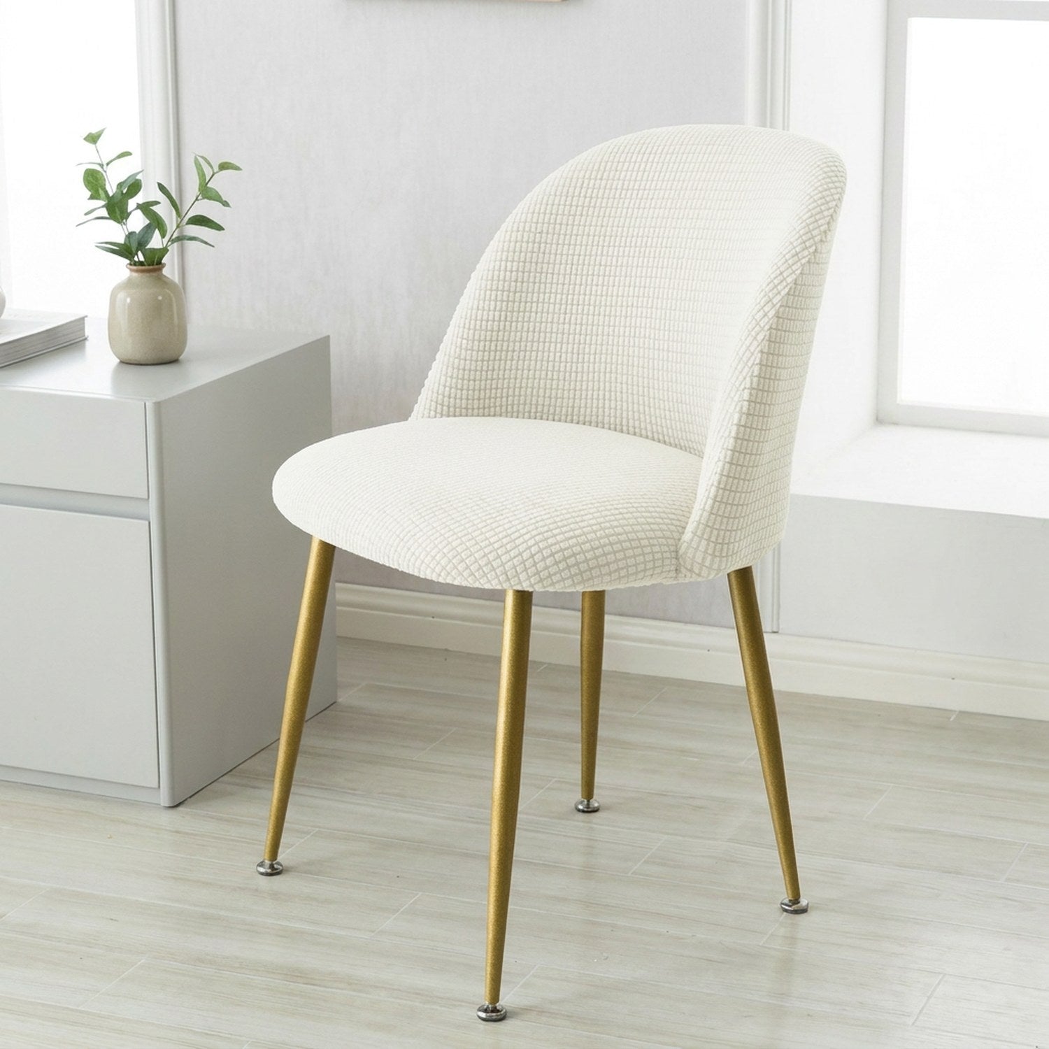 Housse de chaise blanche extensible ajustée sur une chaise scandinave