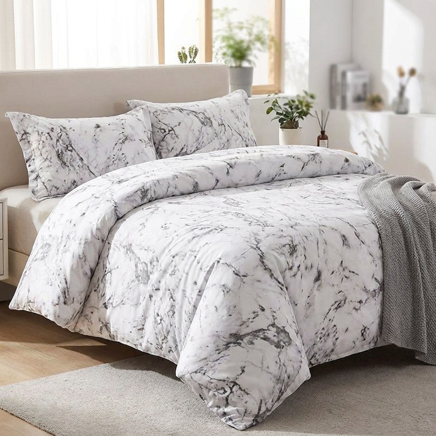 Parure de lit effet marbre blanc sur un lit dans une chambre moderne lumineuse