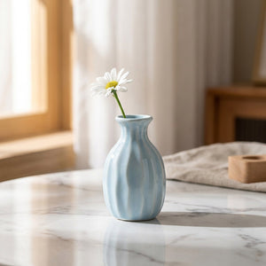 Vase soliflore en céramique côtelé bleu pastel avec une fleur unique